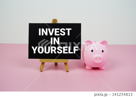 Invest in Yourself text written on paper card with easel and piggy bank Invest in Yourself text written on paper card with easel and piggy bank 141254813
