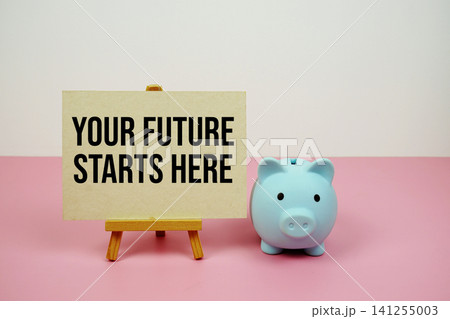 Your Future Starts Here text written on paper card with easel and piggy bank Your Future Starts Here text written on paper card with easel and piggy bank 141255003