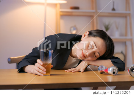 ビールを飲んで酔っ払うスーツの女性 ビールを飲んで酔っ払うスーツの女性 141255204