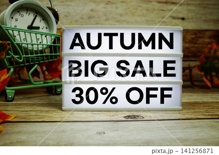Autumn Big Sale 30% off text with trolley shopping cart and alarm clock decoration with maple leaf on wooden background Autumn Big Sale 30% off text with trolley shopping cart and alarm clock decoration with maple leaf on wooden background 141256871