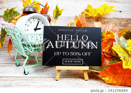 Autumn Sale 50% off Special Offer text with alarm clock and maple leaf decoration on wooden background Autumn Sale 50% off Special Offer text with alarm clock and maple leaf decoration on wooden background 141256884