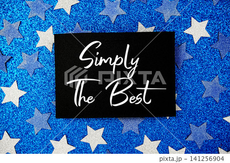 Simply The Best text written on paper card with star glitter on blue background Simply The Best text written on paper card with star glitter on blue background 141256904