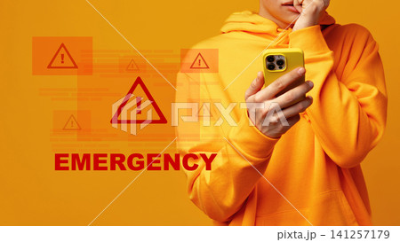 Man receiving emergency alerts on mobile phone while standing against orange background during the day Man receiving emergency alerts on mobile phone while standing against orange background during the day 141257179