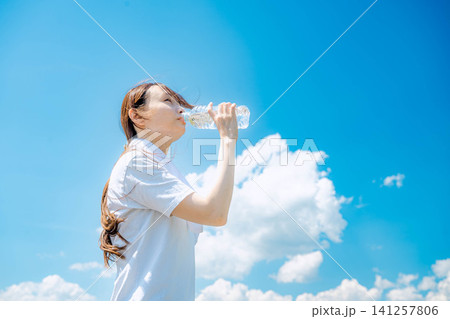 空を見上げて水を飲む女性 空を見上げて水を飲む女性 141257806