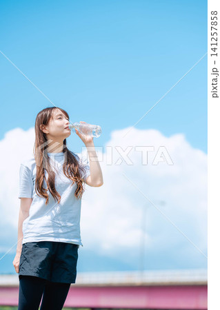 青空の下水を飲む女性の全身 141257858