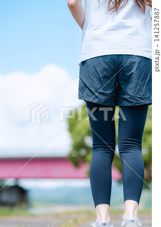 青空を背景に立つ女性の後ろ姿 青空を背景に立つ女性の後ろ姿 141257887