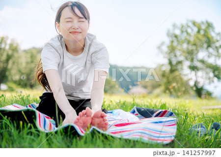 前屈ストレッチで満面の笑みを見せる女性 前屈ストレッチで満面の笑みを見せる女性 141257997