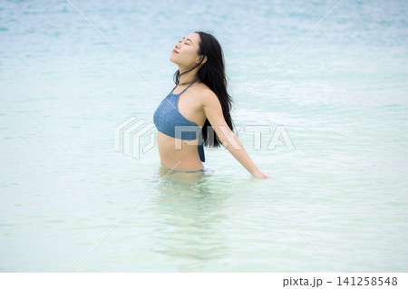 沖縄の海に入る水着姿の女性 沖縄の海に入る水着姿の女性 141258548