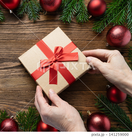 Hands holding Christmas gift box ribbon Hands holding Christmas gift box ribbon 141259000