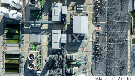 Aerial view combined cycle power plant with cooling tower and substation under blue sky, Industrial infrastructure of electric power station, exhaust stack and cooling systems. Aerial view combined cycle power plant with cooling tower and substation under blue sky, Industrial infrastructure of electric power station, exhaust stack and cooling systems. 141259163