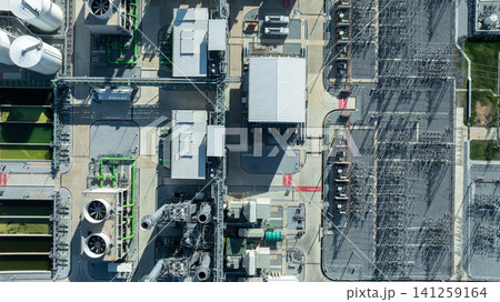 Aerial view combined cycle power plant with cooling tower and substation under blue sky, Industrial infrastructure of electric power station, exhaust stack and cooling systems. Aerial view combined cycle power plant with cooling tower and substation under blue sky, Industrial infrastructure of electric power station, exhaust stack and cooling systems. 141259164