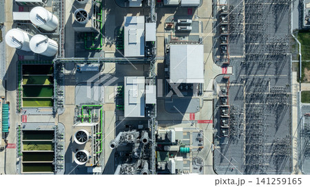 Aerial view combined cycle power plant with cooling tower and substation under blue sky, Industrial infrastructure of electric power station, exhaust stack and cooling systems. Aerial view combined cycle power plant with cooling tower and substation under blue sky, Industrial infrastructure of electric power station, exhaust stack and cooling systems. 141259165