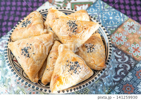 Traditional Asian food pies with sesame seeds on plate Traditional Asian food pies with sesame seeds on plate 141259930