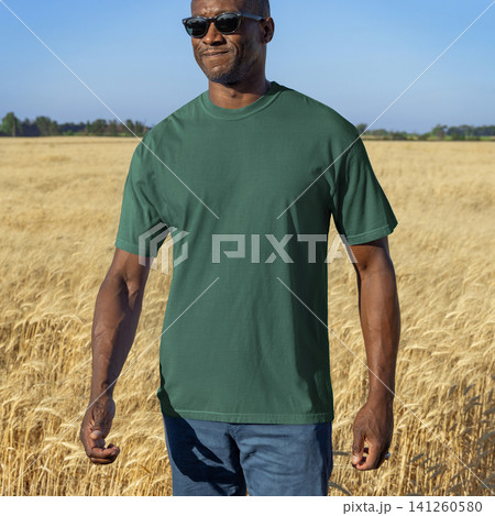Blank green t-shirt mockup on black man in wheat field at sunset, front view with copy space Blank green t-shirt mockup on black man in wheat field at sunset, front view with copy space 141260580