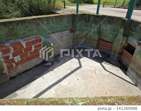 A concrete chamber with red brick features is shown, used for managing water levels in the agricultural wetlands of Pego. This structure plays a role in irrigation. A concrete chamber with red brick features is shown, used for managing water levels in the agricultural wetlands of Pego. This structure plays a role in irrigation. 141260986