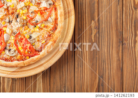 delicious pizza with chicken, mushrooms, cheese, tomatoes and corn on a wooden background delicious pizza with chicken, mushrooms, cheese, tomatoes and corn on a wooden background 141262193