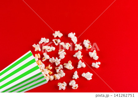 box with popcorn striped in different colors on a red background box with popcorn striped in different colors on a red background 141262751
