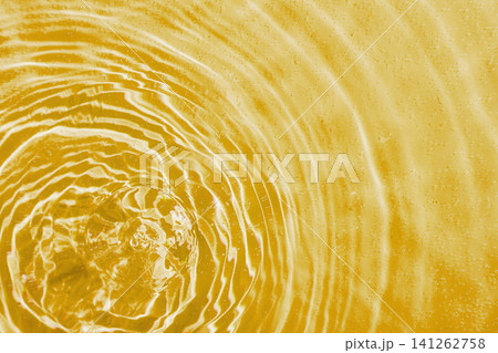 drops on water with circles on a yellow background 141262758