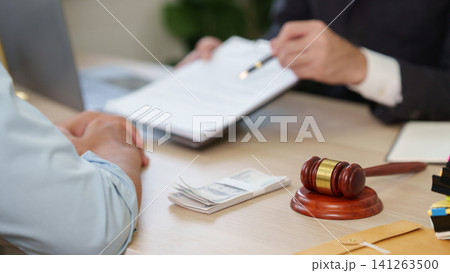 Gavel and stack of money on desk during legal consultation 141263500