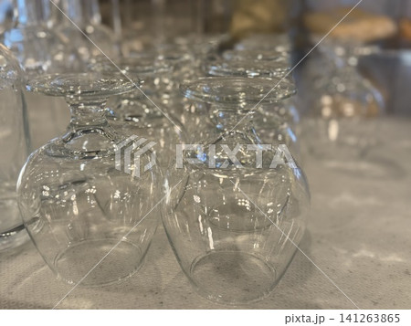 Clear wine glasses arranged upside down on a textured surface background for elegant dining setup Clear wine glasses arranged upside down on a textured surface background for elegant dining setup 141263865
