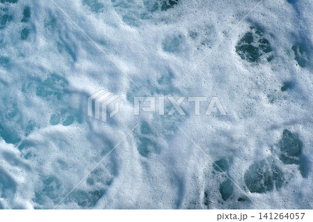 Close-up image of ocean waves displaying white foam and turquoise water, highlighting the dynamic texture and movement of the sea surface Close-up image of ocean waves displaying white foam and turquoise water, highlighting the dynamic texture and movement of the sea surface 141264057
