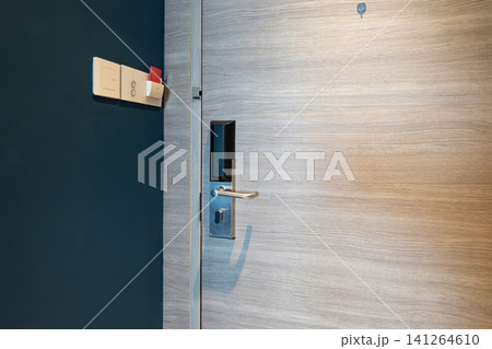 Hotel key card power switch beside digital door lock, room access shows a guest inserting a key card into the wall slot to activate electricity and in room appliances. Hotel key card power switch beside digital door lock, room access shows a guest inserting a key card into the wall slot to activate electricity and in room appliances. 141264610