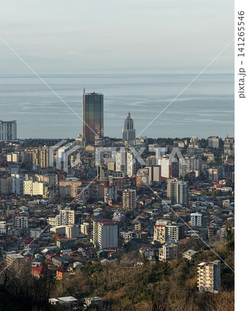 Panoramic view of Batumi city skyline with tall buildings and sea horizon under warm evening light Panoramic view of Batumi city skyline with tall buildings and sea horizon under warm evening light 141265546