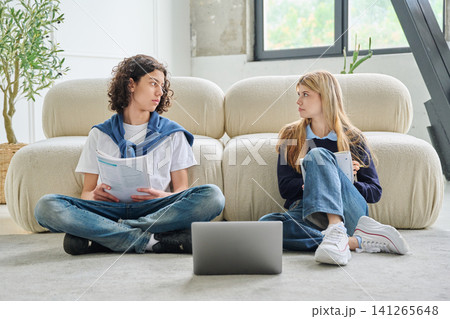 Two teenage students looking at each other while studying Two teenage students looking at each other while studying 141265648