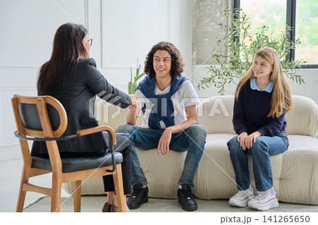 Teen boy shaking hands with psychologist at session Teen boy shaking hands with psychologist at session 141265650