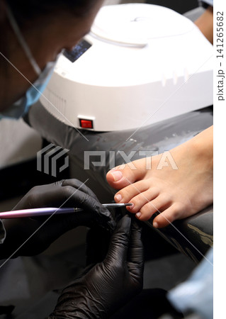 A woman's feet during a pedicure. Woman getting pedicure in beauty salon, closeup. A pedicurist working at a beauty salon. Manicure services. Nail art. Beauty salon concept: pedicures. A woman's feet during a pedicure. Woman getting pedicure in beauty salon, closeup. A pedicurist working at a beauty salon. Manicure services. Nail art. Beauty salon concept: pedicures. 141265682