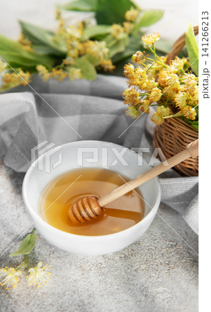 Linden honey with dipper and fresh basswood flowers Linden honey with dipper and fresh basswood flowers 141266213