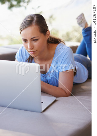 House, remote work and woman on sofa with laptop for working from home, freelance job and career. Business, startup and person on computer for typing email, planning or internet research on website 141267107