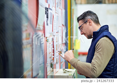 Man, business and board for checking calendar or schedule for shipping details, supplier information and warehouse. Male person, clipboard and notes for orders or inventory, poster and distribution 141267333