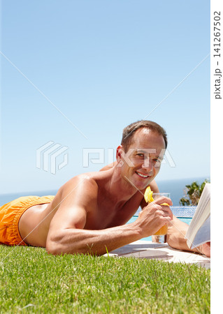 Man, book and reading on grass in portrait by ocean with knowledge, relax and swimming pool on vacation. Person, cocktail and novel on lawn with pride, topless or outdoor for holiday by sea in Naples Man, book and reading on grass in portrait by ocean with knowledge, relax and swimming pool on vacation. Person, cocktail and novel on lawn with pride, topless or outdoor for holiday by sea in Naples 141267502