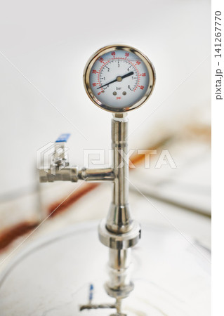 Beer, production and temperature with steel in factory for winery, alcohol and drink manufacturing or distillery. Thermometer, container and fermentation vessel in closeup for brewery and industry Beer, production and temperature with steel in factory for winery, alcohol and drink manufacturing or distillery. Thermometer, container and fermentation vessel in closeup for brewery and industry 141267770