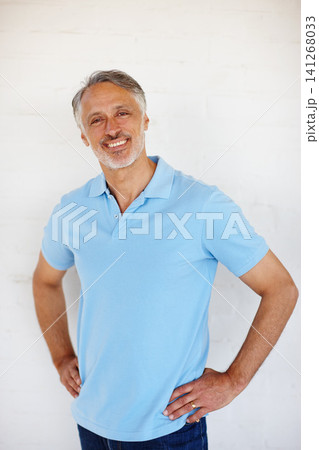 Portrait, confidence and smile of senior man on brick wall for fashion isolated on a white background in Switzerland. Face, mature and happy person in casual clothes, shirt and positive for style 141268033