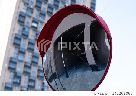 A Striking Urban Reflection: Red Convex Mirror Capturing the Distorted Facade of a Modern Building in a City Setting A Striking Urban Reflection: Red Convex Mirror Capturing the Distorted Facade of a Modern Building in a City Setting 141268069