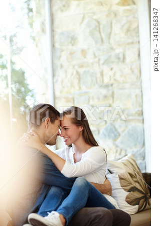 Home, couple and forehead for romance, embrace and lap or care on couch in living room. Happy people, touch and smile for pride in relationship or commitment, loyalty and connection on hug date 141268347