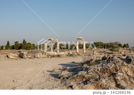 Discover the fascinating ancient site of Pamukkale featuring well-preserved ruins and mesmerizing natural formations during a serene afternoon. 141269136