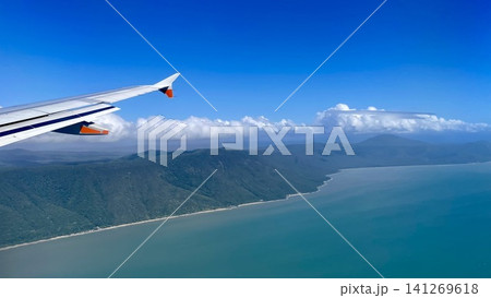 機窓から見下ろす澄んだマリンブルーの海と険しい山地の海岸 機窓から見下ろす澄んだマリンブルーの海と険しい山地の海岸 141269618