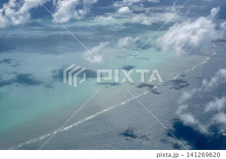 飛行機の窓から見下ろす美しいサンゴ礁とエメラルドグリーンの海 飛行機の窓から見下ろす美しいサンゴ礁とエメラルドグリーンの海 141269620