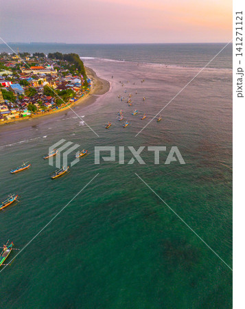 Sunset beach in Indonesia with golden waves and pristine white sand capturing tropical beauty and serene coastal atmosphere Sunset beach in Indonesia with golden waves and pristine white sand capturing tropical beauty and serene coastal atmosphere 141271121