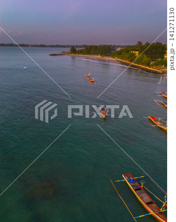 Sunset beach in Indonesia with golden waves and pristine white sand capturing tropical beauty and serene coastal atmosphere Sunset beach in Indonesia with golden waves and pristine white sand capturing tropical beauty and serene coastal atmosphere 141271130