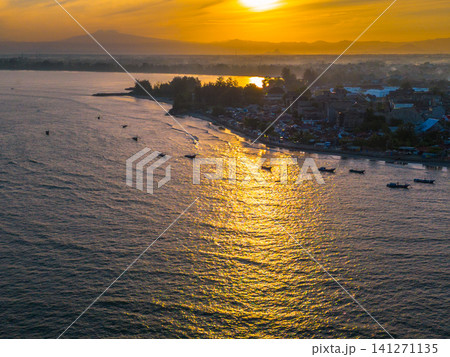 Sunset beach in Indonesia with golden waves and pristine white sand capturing tropical beauty and serene coastal atmosphere Sunset beach in Indonesia with golden waves and pristine white sand capturing tropical beauty and serene coastal atmosphere 141271135