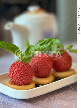Delicate lychee dessert with mint and biscuit served on a white plate Delicate lychee dessert with mint and biscuit served on a white plate 141271256