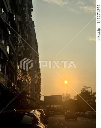 Golden hour sunset over a busy city street with apartment buildings Golden hour sunset over a busy city street with apartment buildings 141271261