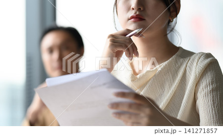 書類を手に考え込む女性 書類を手に考え込む女性 141271857
