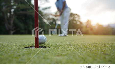 Golfers are putting golf in the evening golf course golf backglound. Golfers are putting golf in the evening golf course golf backglound. 141272081