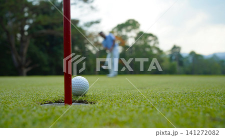 Golfers are putting golf in the evening golf course golf backglound. Golfers are putting golf in the evening golf course golf backglound. 141272082