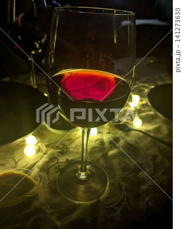 Glowing red wine in elegant glass Glowing red wine in elegant glass 141273630